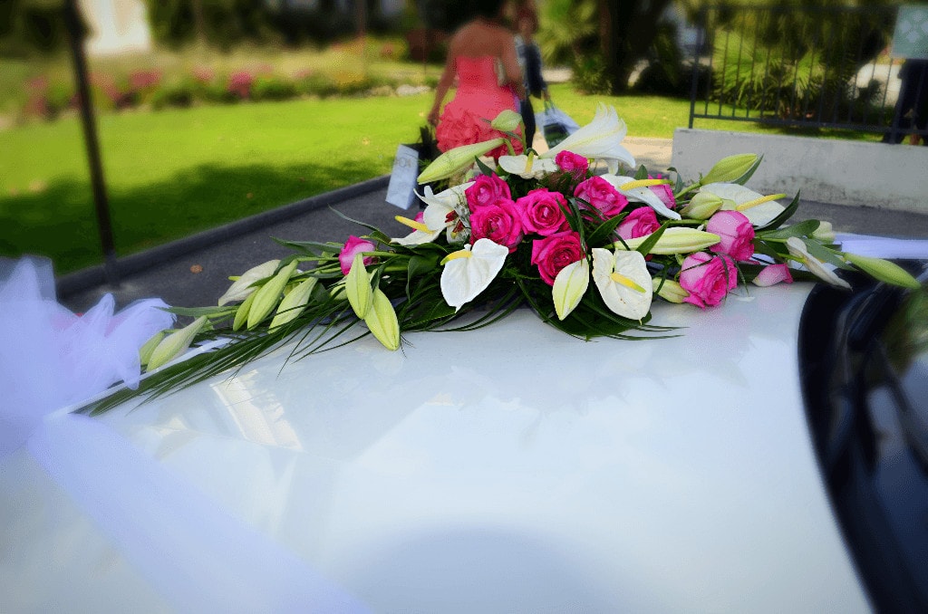 Décoration avec des fleurs sur un capot de voiture pour un mariage